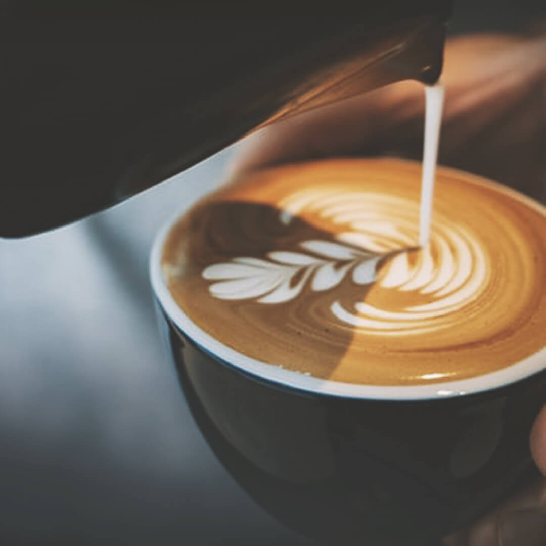 Latte Art wird in Cappuccino gegossen