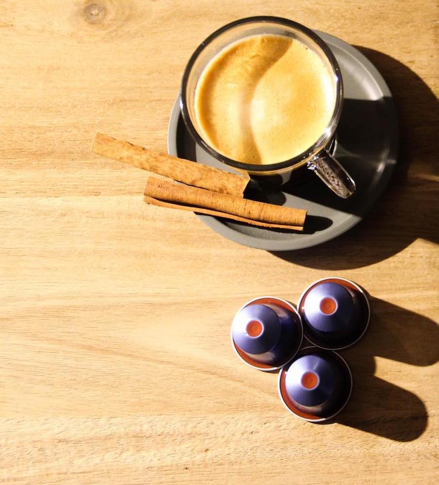 Gourmesso Kapseln mit Kaffee in Tasse auf Tisch