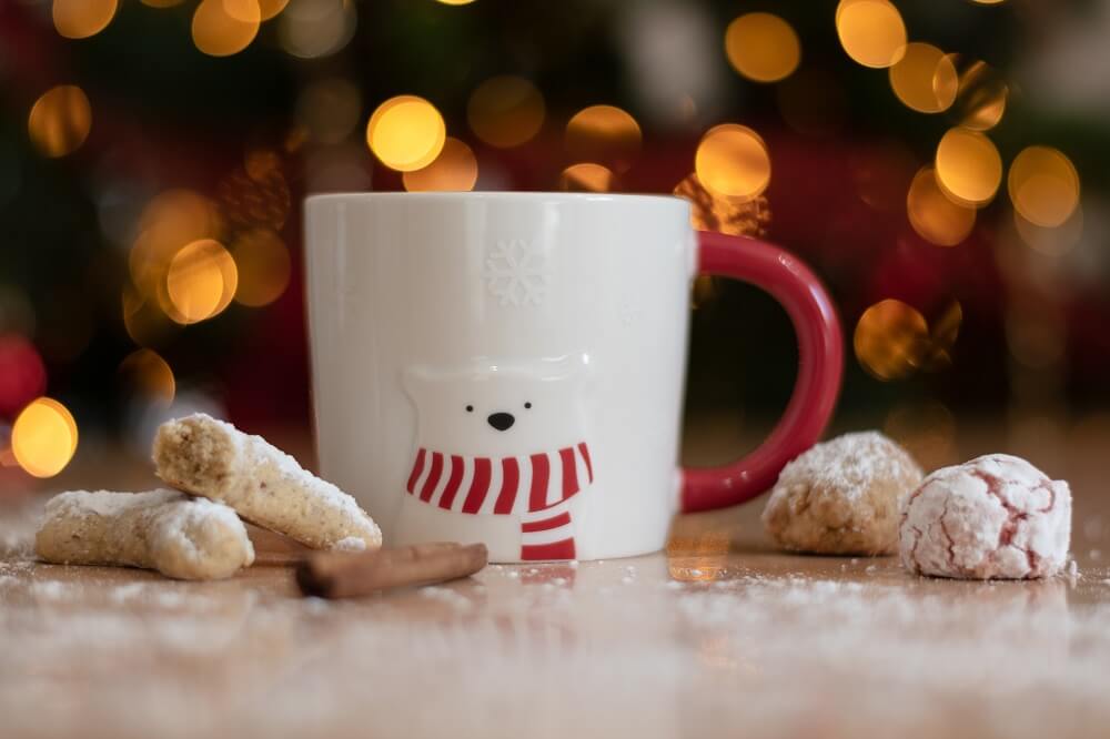 Weihnachtskaffee in Tasse mit Weihnachtssüßigkeiten auf Tisch
