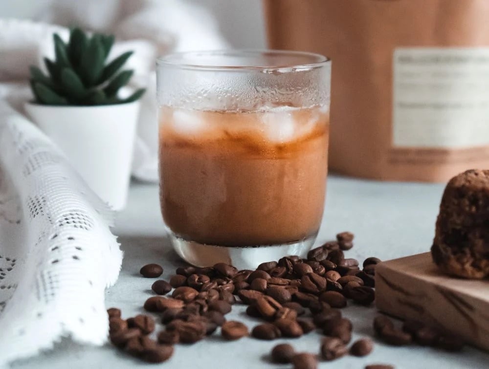 Cold Brew im Glas neben Kaffeebohnen Cold Brew im Glas neben Kaffeebohnen