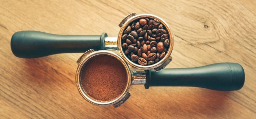kaffeebohnen und kaffeepulver in siebträger kaffeebohnen und kaffeepulver in siebträger
