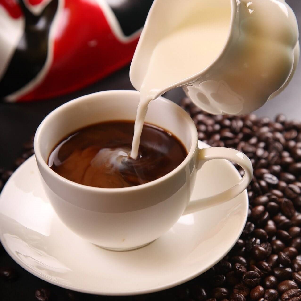 Milch wird in Tasse gegossen