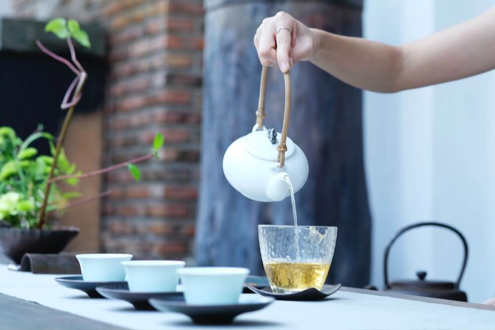 Teezeremonie mit grünen Teeblättern
