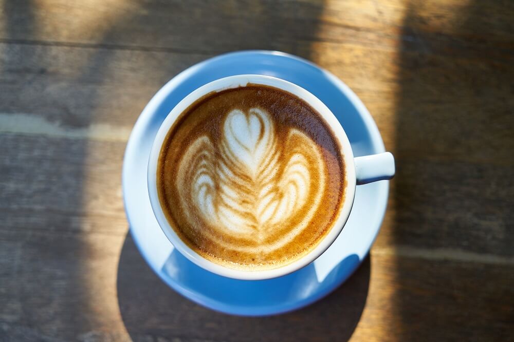 Cappuccino mit Latte Art in blauer Tasse