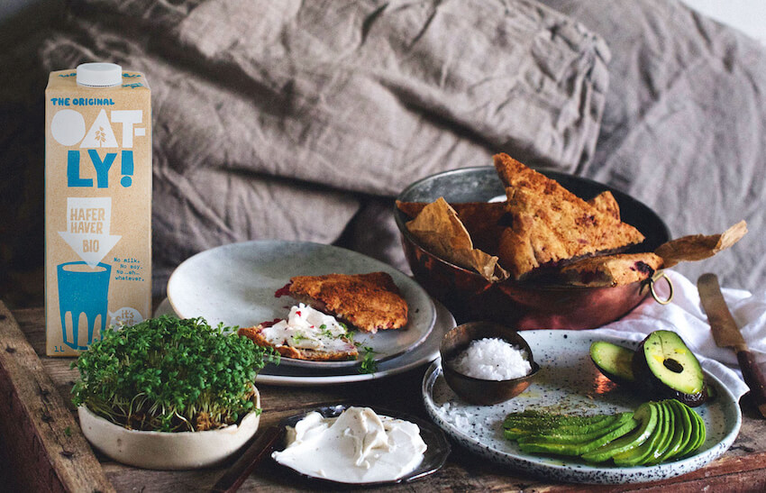Oatly Bio Haferdrink auf Tisch mit Frühstück