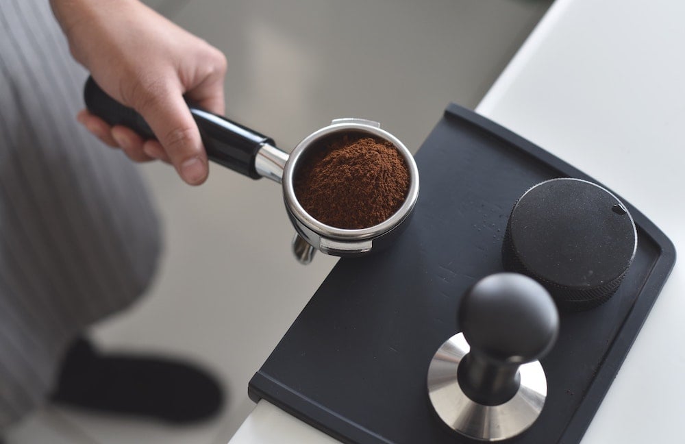Espresso wird auf Tampingmatte getamped