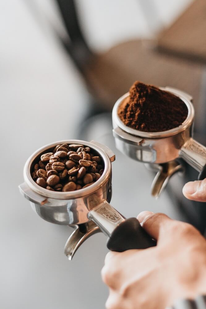 Bohnen und Kaffeemehl im Siebträger bereit zum Tampen