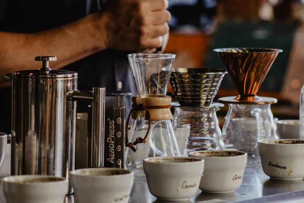 Kaffeemaschinen, Kaffeebereiter und Kaffeemühlen auf Tisch Kaffeemaschinen, Kaffeebereiter und Kaffeemühlen auf Tisch